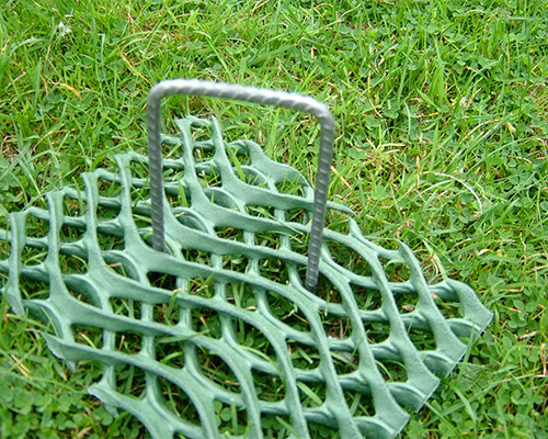 Tenax ground protection mesh panel being carried using a U-pin handle, showing ease of handling during installation