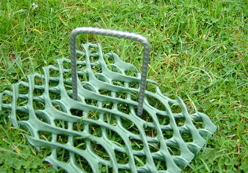 Tenax ground protection mesh panel being carried using a U-pin handle, showing ease of handling during installation