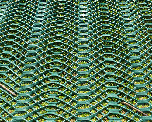 Top-down close-up of Tenax GP Flex mesh showing the distinctive oscillated wave texture of the HDPE reinforcement grid