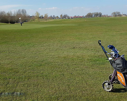 Golfer with trolley on a Tenax GP Flex reinforced grass fairway or path at a golf course or park, showing turf reinforcement in a golf setting