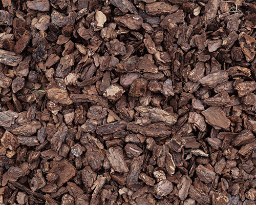 Close-up of dark brown bark mulch used as a comparison alternative to Tenax grass reinforcement mesh for trail and path stabilization