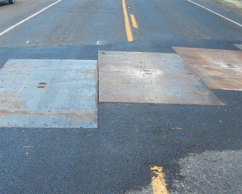 Steel road plates on tarmac as a comparison alternative to Tenax Trackway HDPE ground protection mats for construction site access