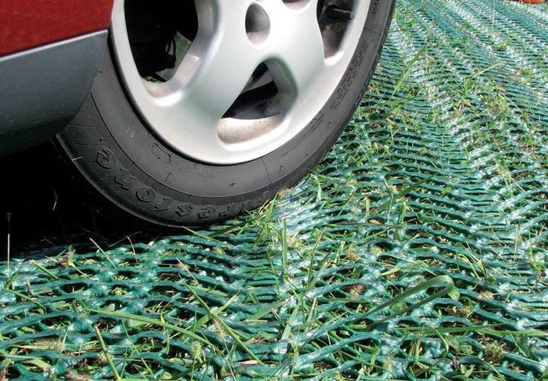 Close-up of a vehicle tire on installed Tenax Keep-It-Green ground protection mesh, showing load bearing on reinforced turf