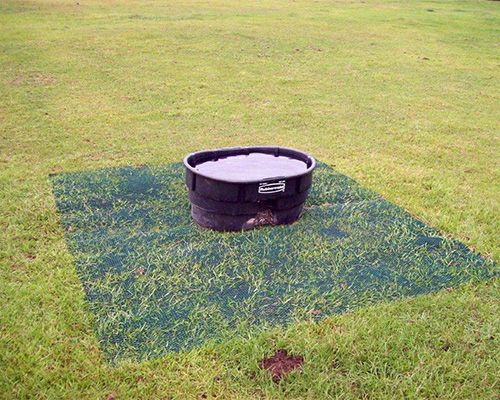 Water trough surrounded by Tenax GP Flex ground protection mesh on a farm, showing livestock area reinforcement