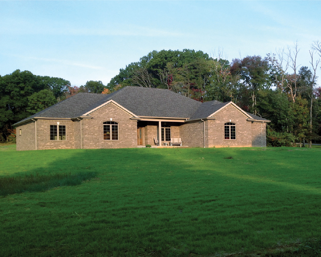 Residential house with a wide reinforced green lawn, showing Tenax mesh providing a clean turf result