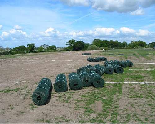 Tenax GP Flex ground protection mesh rolls stacked on bare ground before installation, ready for large-scale deployment